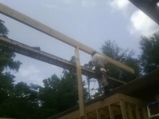 Carpenter setting a ridge beam over a new addition frame — Ice Dam Removal by Roofing Brothers in West Salem