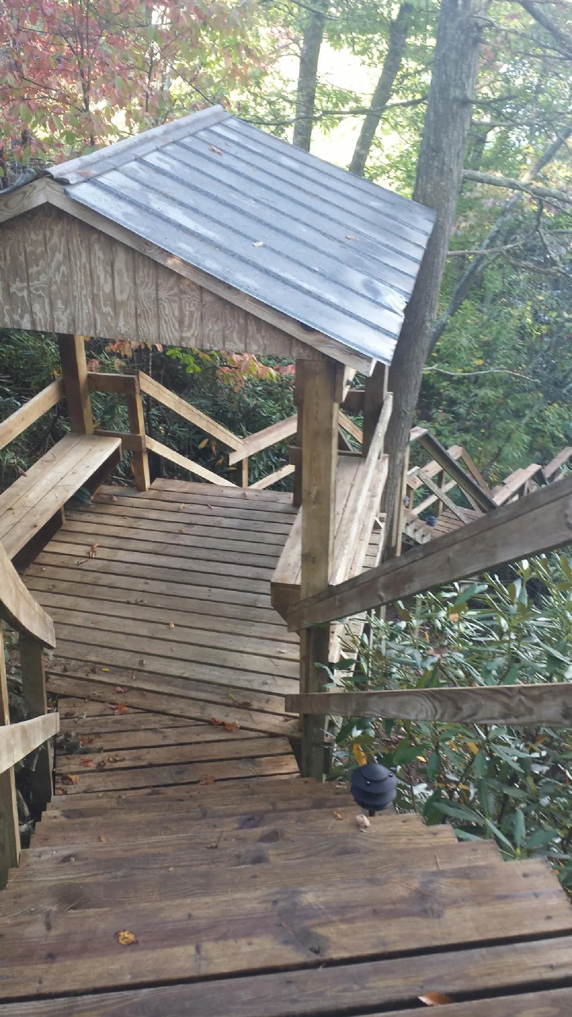 Metal roofed shelter over wooden steps on a wooded walkway — Skylight Repair & Installation work by our crew in West Salem