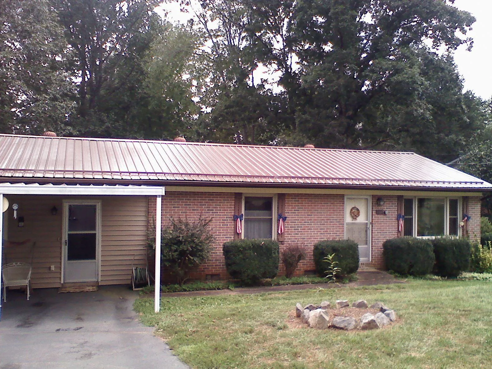 Bronze metal roof and carport on a brick ranch home — Roof Repair work by our crew in West Salem